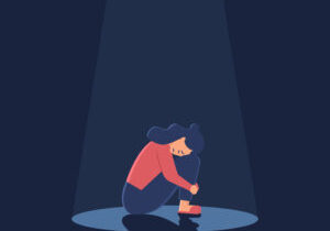 Sad crying lonely young woman sitting on floor in spotlight. Depressed unhappy girl. Female character in depression, sorrow, sadness. Mental disorder or illness.